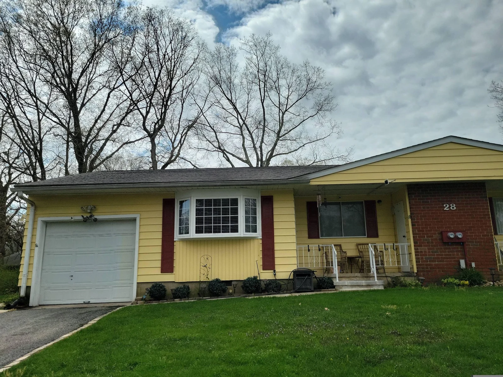Yellow single-story home with a garage and a small porch