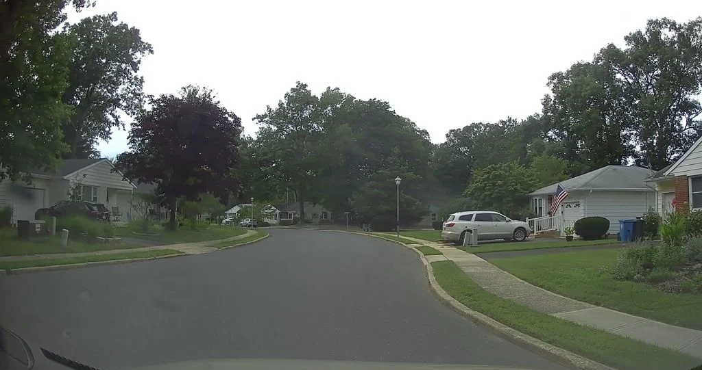 Curving residential street with ranch homes and lawns