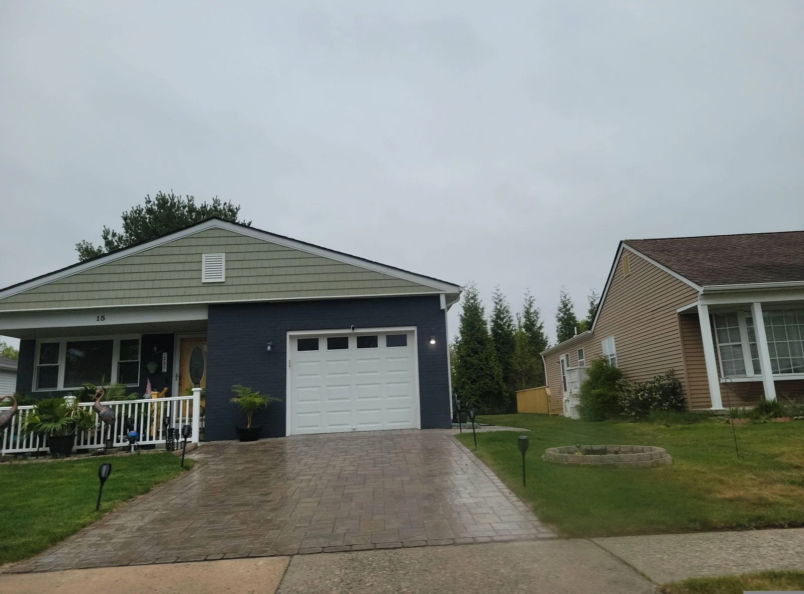 Single-story home with a garage and a paver driveway