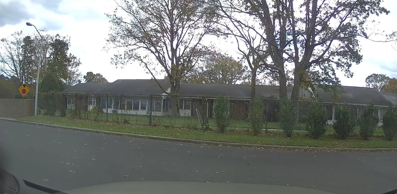 Single-story attached homes with shade trees and a wide lawn