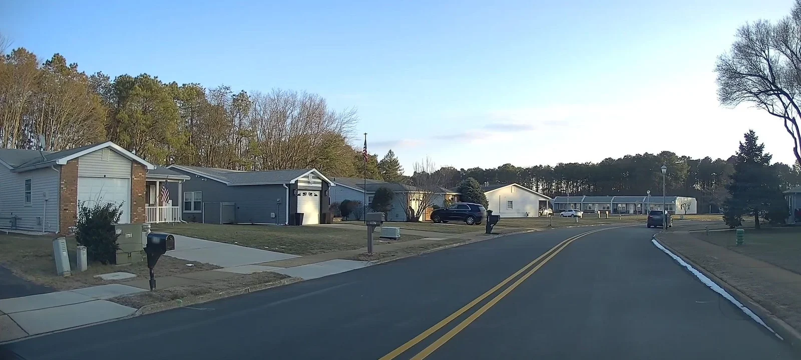 Two-lane street lined with ranch homes and mailboxes