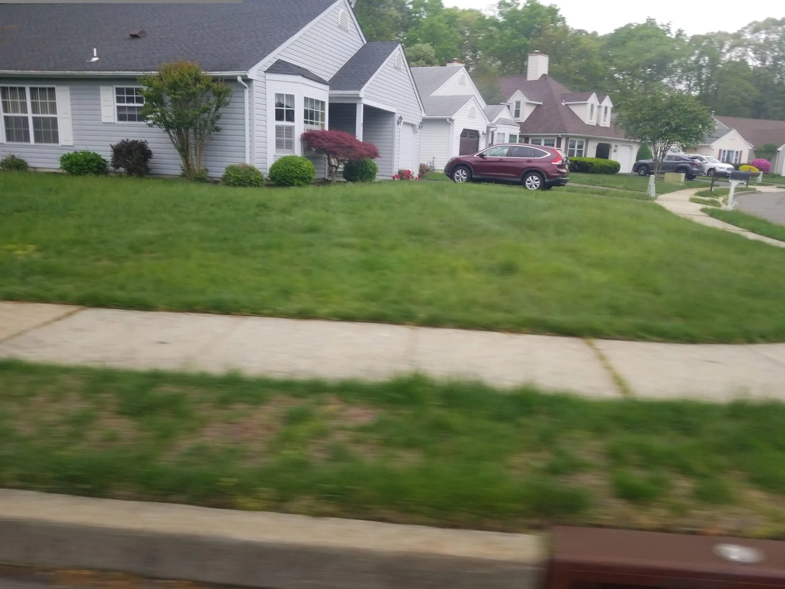 Single-story homes with gray siding and landscaped lawns
