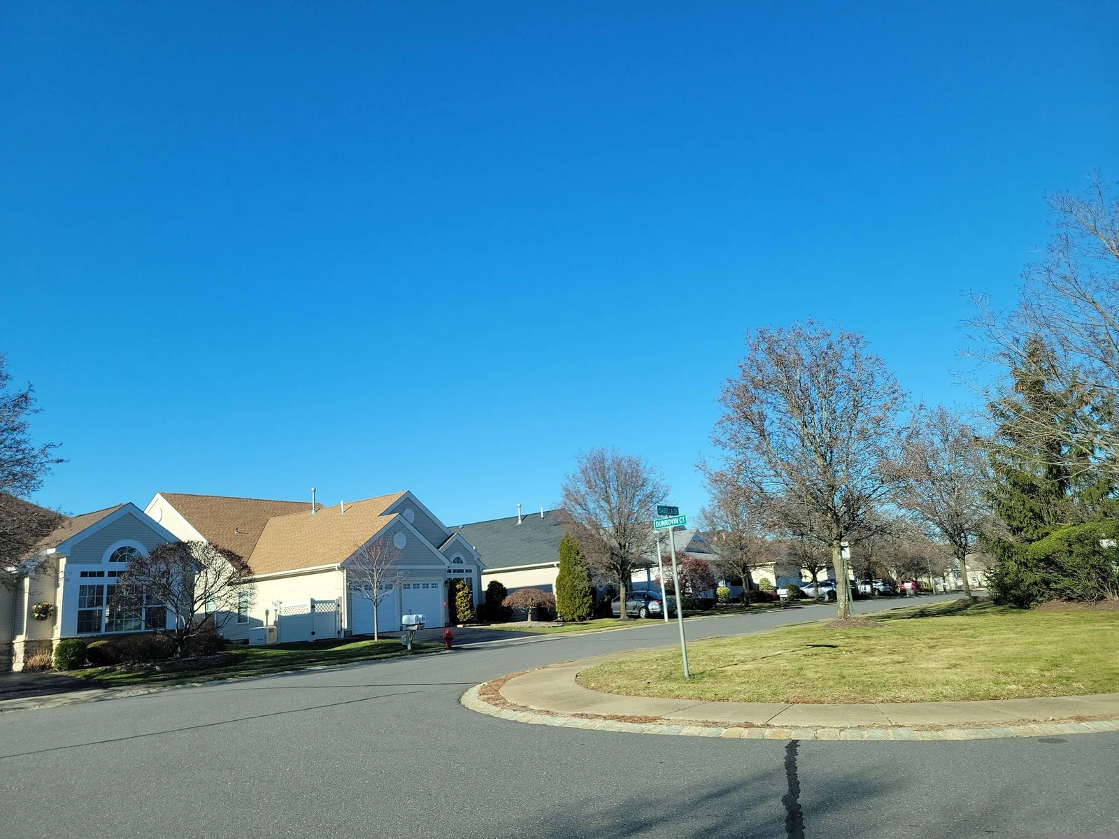 Curving street with a grass island and single-story homes