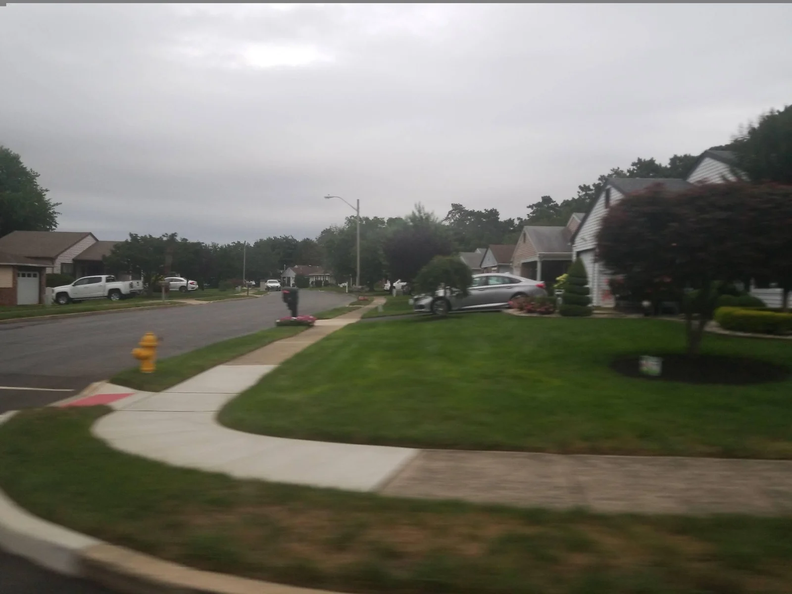 Curving sidewalk beside lawns and single-story homes