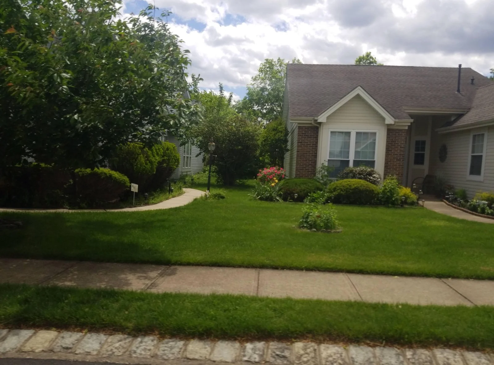Single-story home with gables, landscaping and a lawn