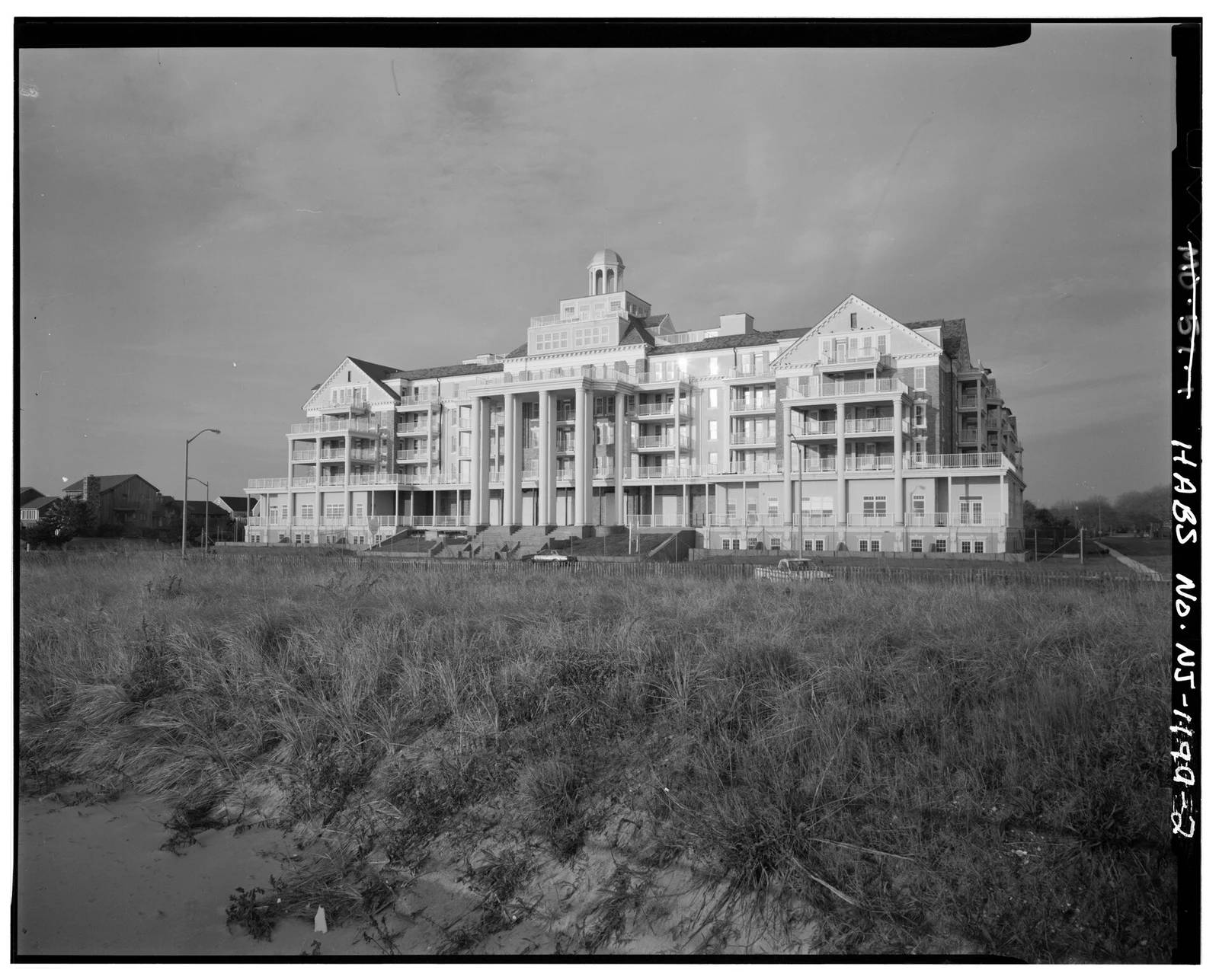 Black and white photo of the Essex and Sussex Hotel east facade seen across dune grass