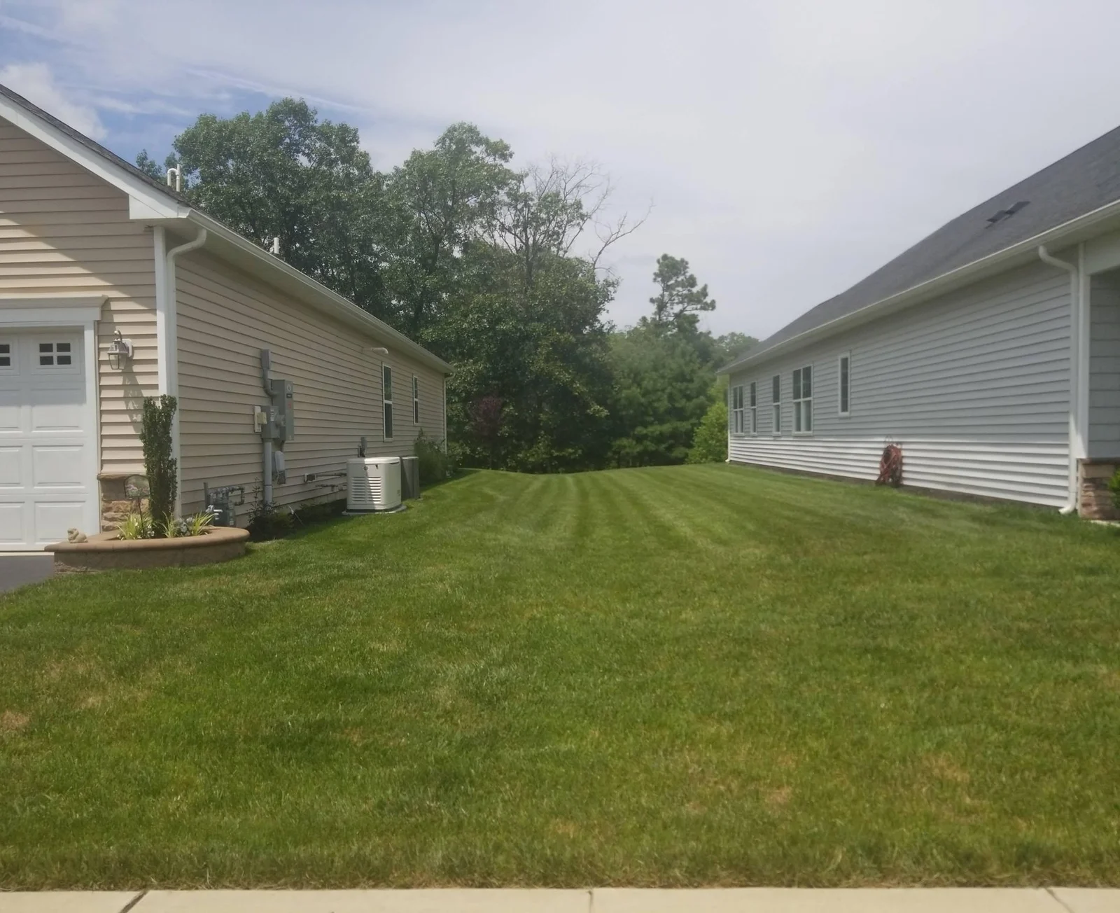 Two single-story homes separated by a wide lawn