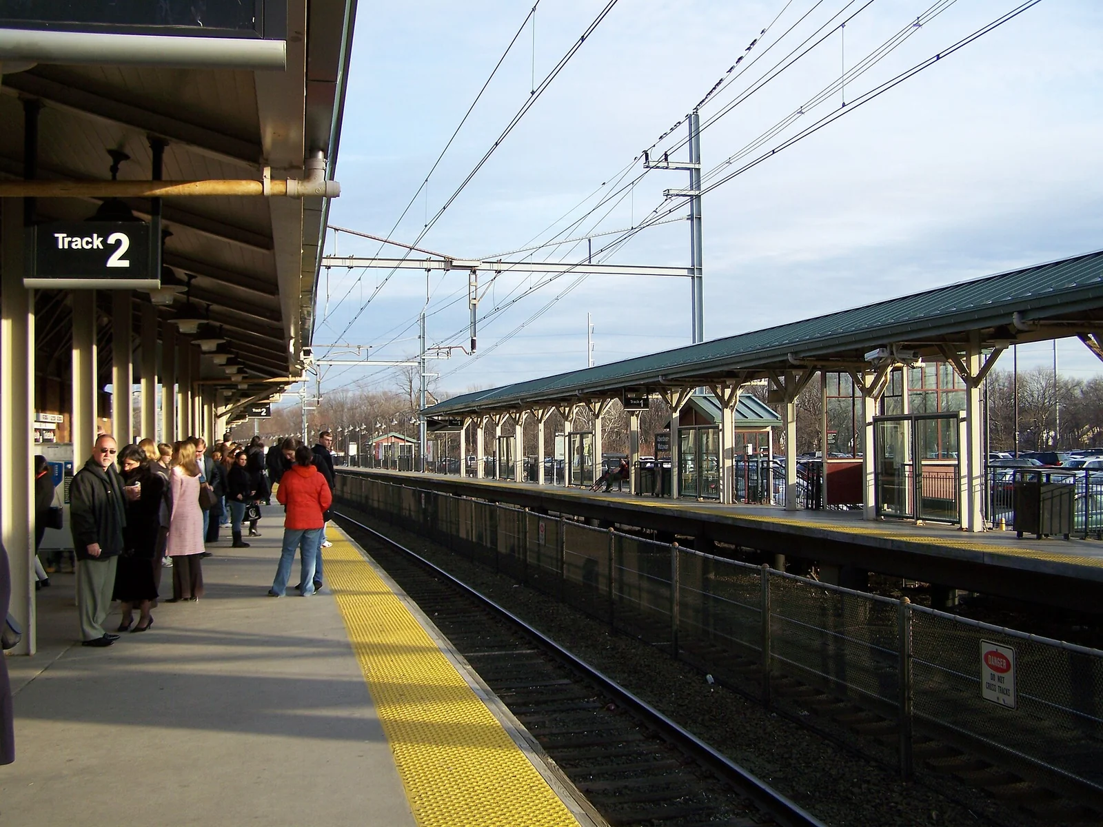 Commuters waiting on the platform at Aberdeen-Matawan station under the overhead train wires