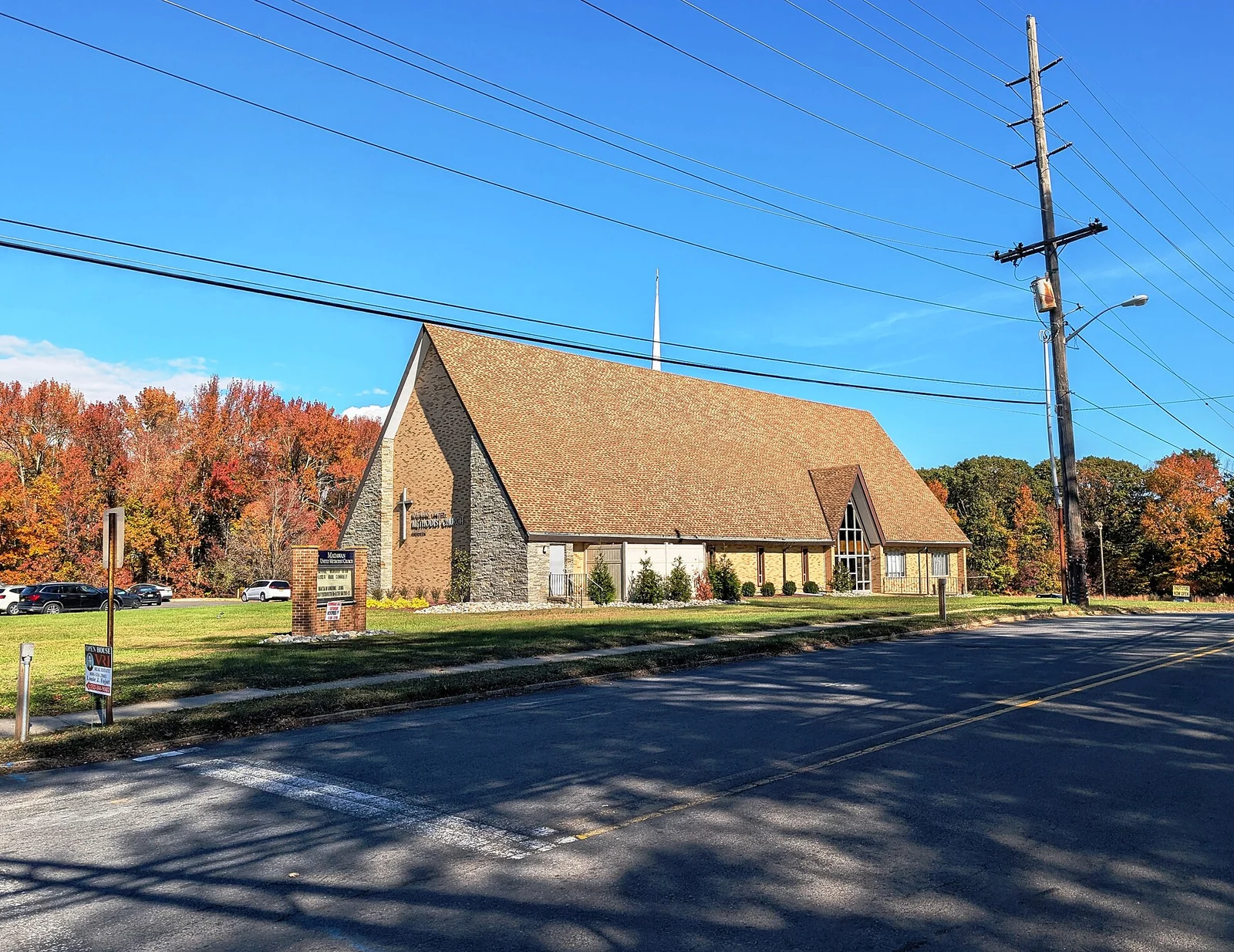 Stone and brick Matawan United Methodist Church on Church Street with bright orange autumn trees