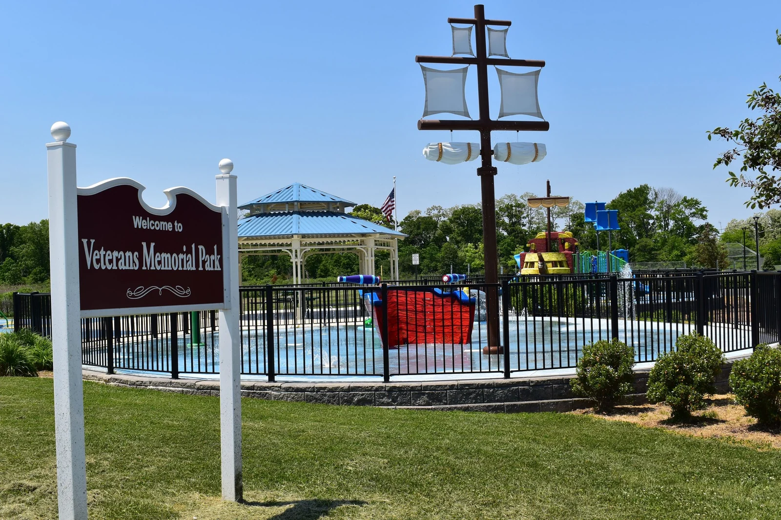 The pirate-ship splash pad and blue-roofed gazebo behind the Welcome to Veterans Memorial Park sign in Cliffwood Beach