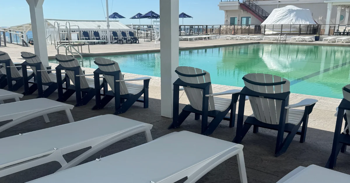 White deck chairs in the shade beside the saltwater pool at the Allenhurst Beach Club