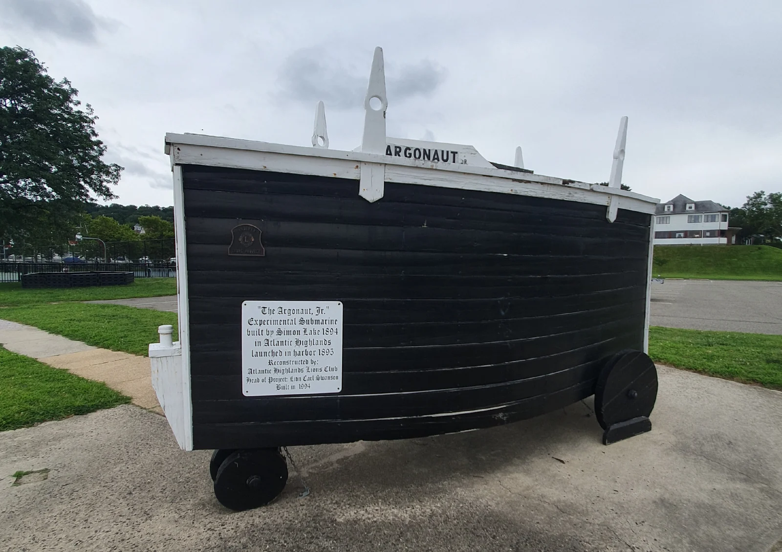 Black wooden replica of the Argonaut Junior submarine on wheels, with a plaque noting Simon Lake built the original in 1894 and launched it in the harbor in 1895