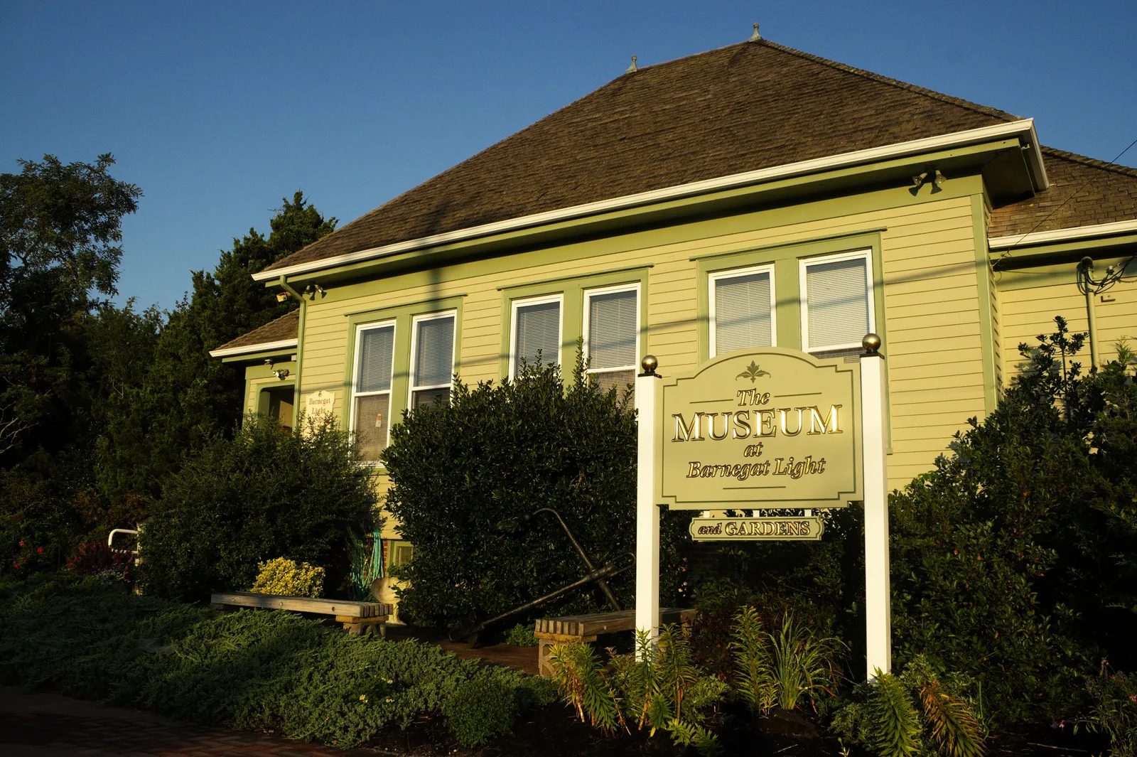 The yellow one-room schoolhouse that houses the Barnegat Light Museum, with its museum sign out front