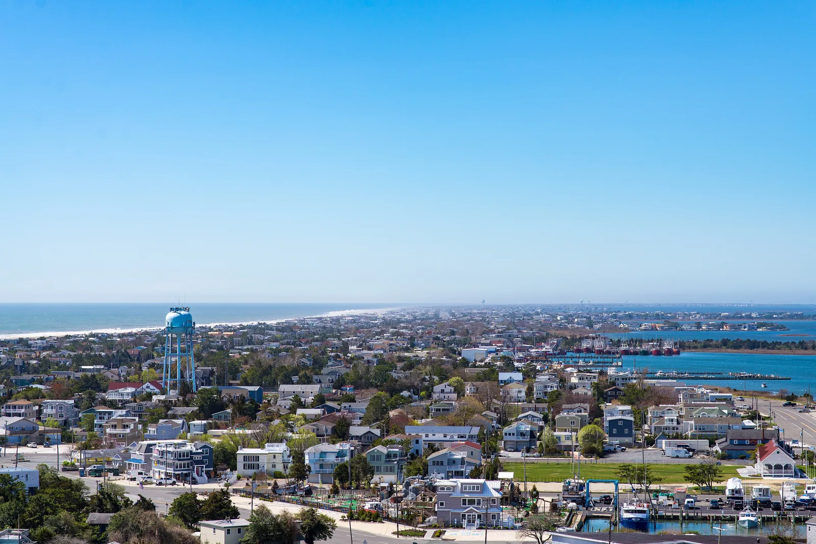 Barnegat Light seen from the top of Barnegat Lighthouse, rooftops and a water tower running south along Long Beach Island between ocean and bay
