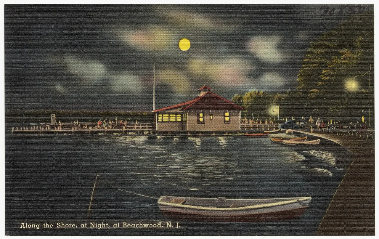 Vintage postcard of a moonlit riverfront pavilion and pier with a rowboat in the foreground