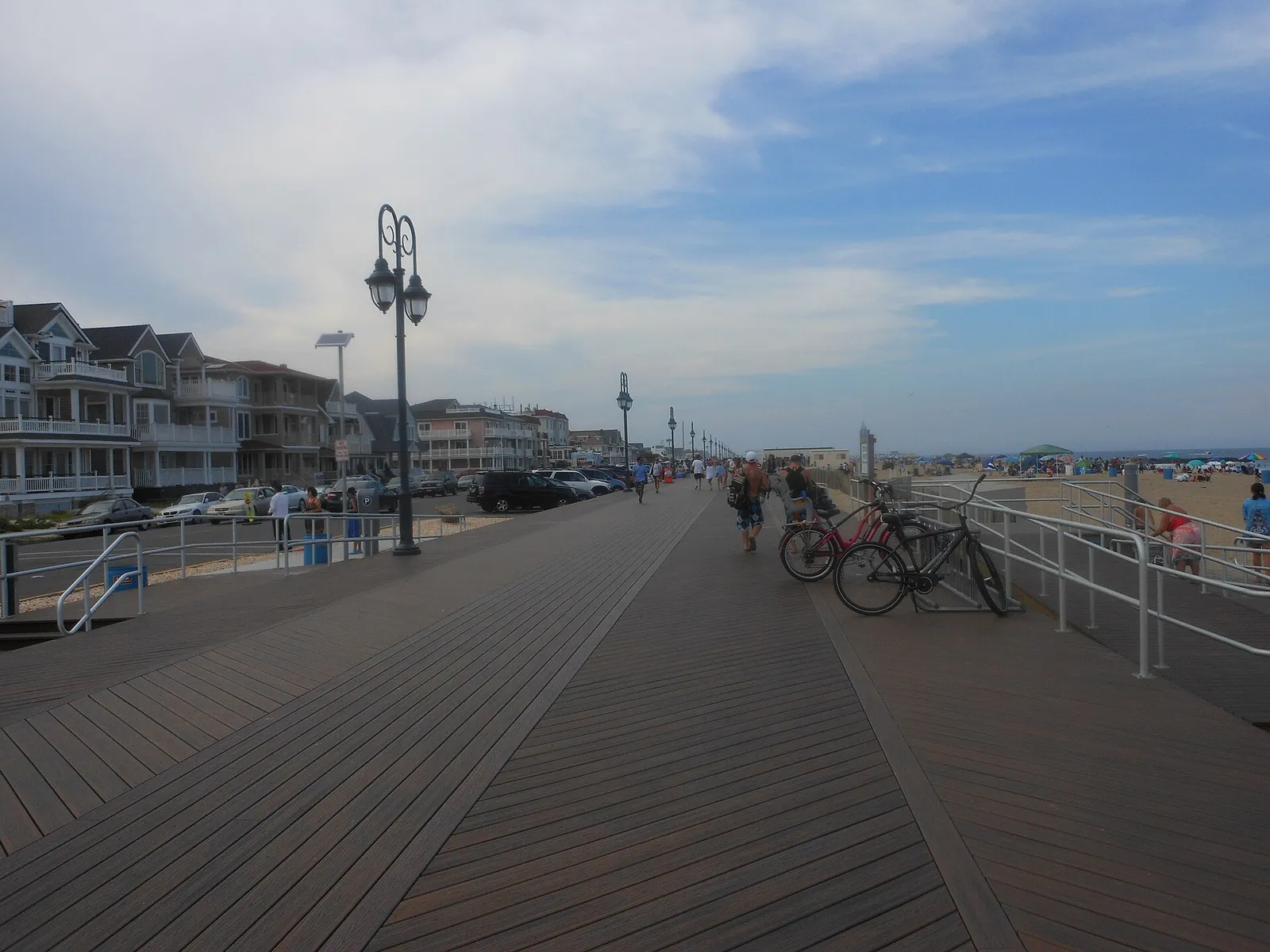 The Belmar boardwalk with lamp posts running along the beach, Ocean Avenue homes on the left