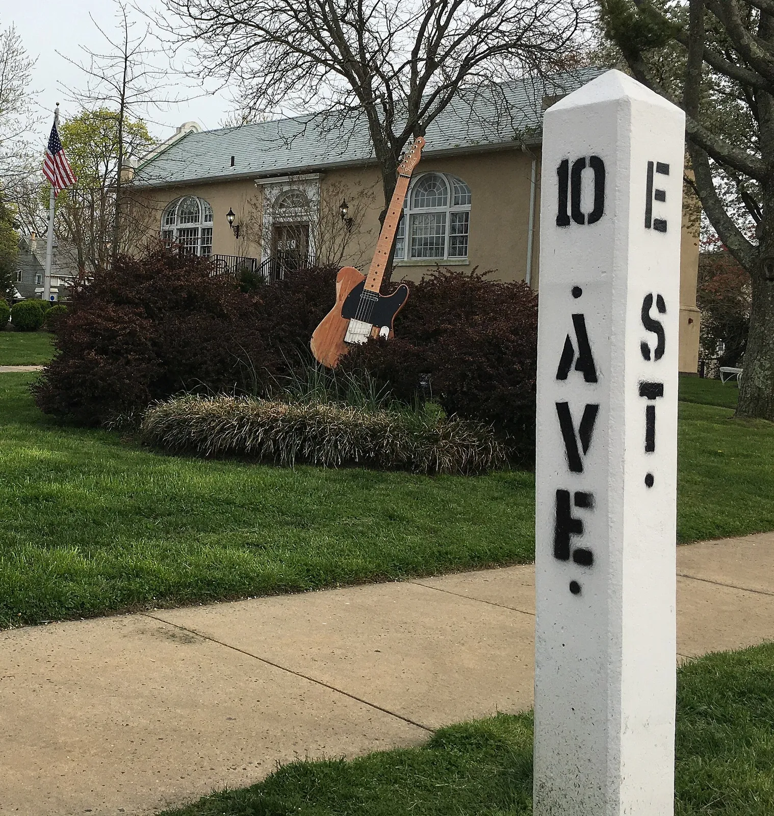 A giant guitar replica beside the 10th Ave and E St. post in front of the Belmar Public Library
