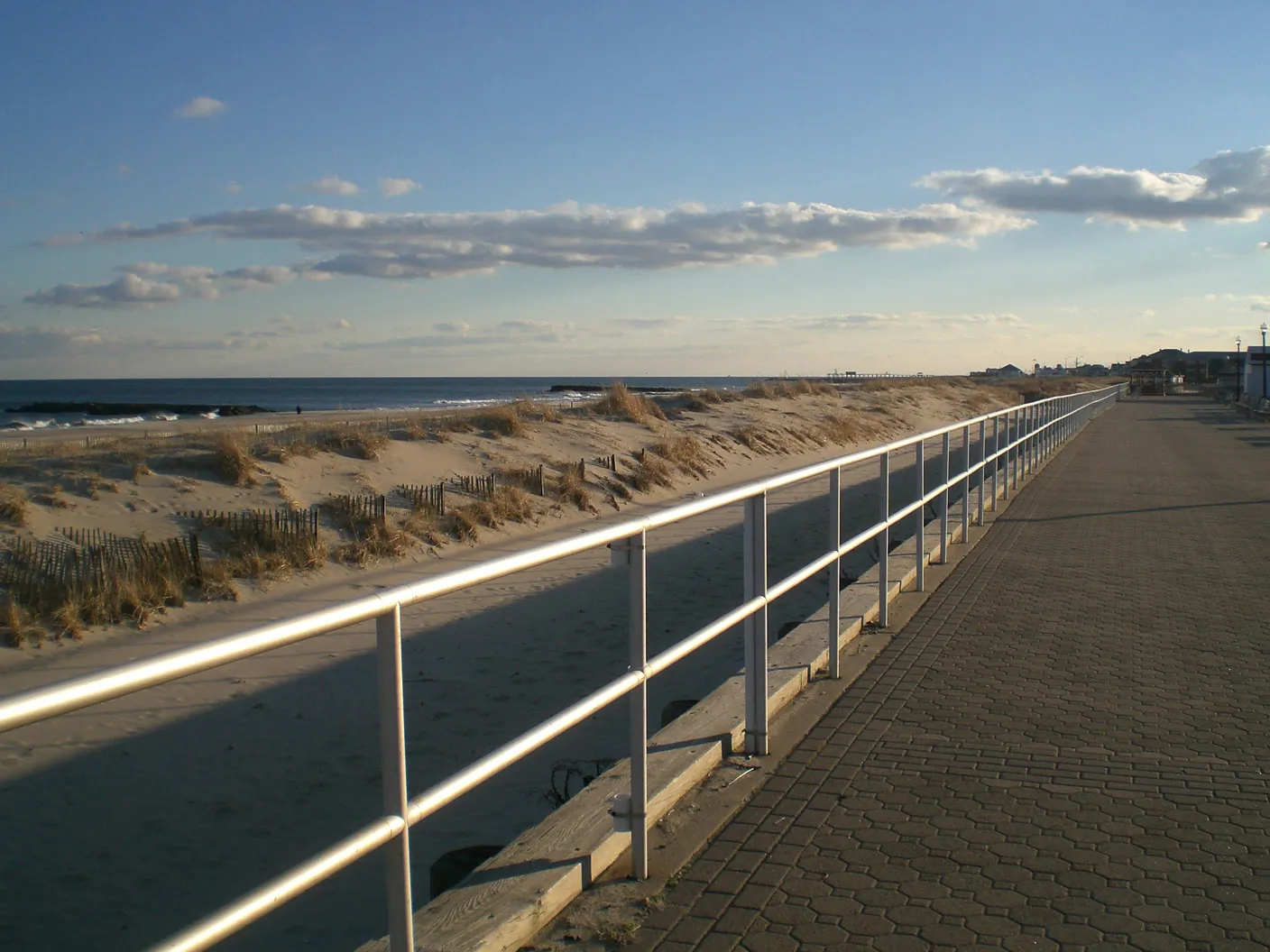 The Bradley Beach boardwalk promenade with its railing running beside the dunes