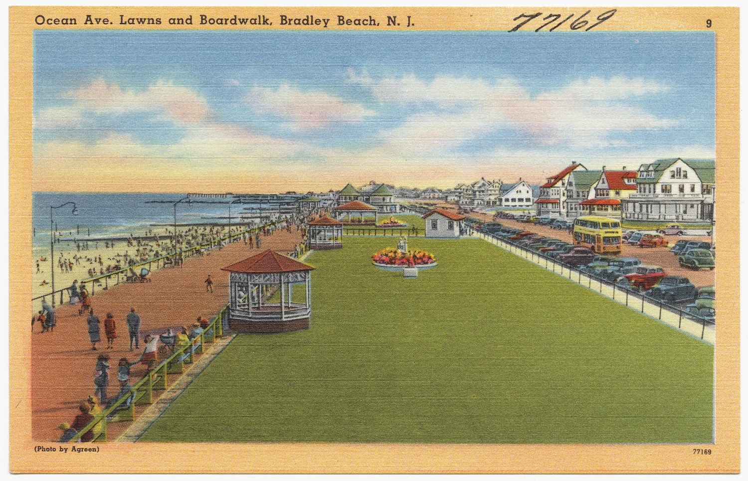 Vintage postcard of the long green Ocean Avenue lawns, a gazebo and the boardwalk crowded with strollers beside the beach