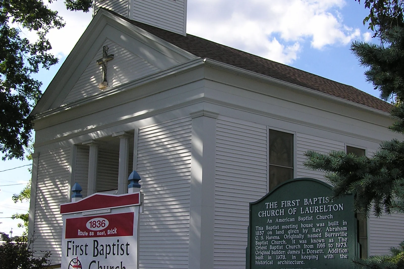 White clapboard church with a cupola and a historical marker in Laurelton