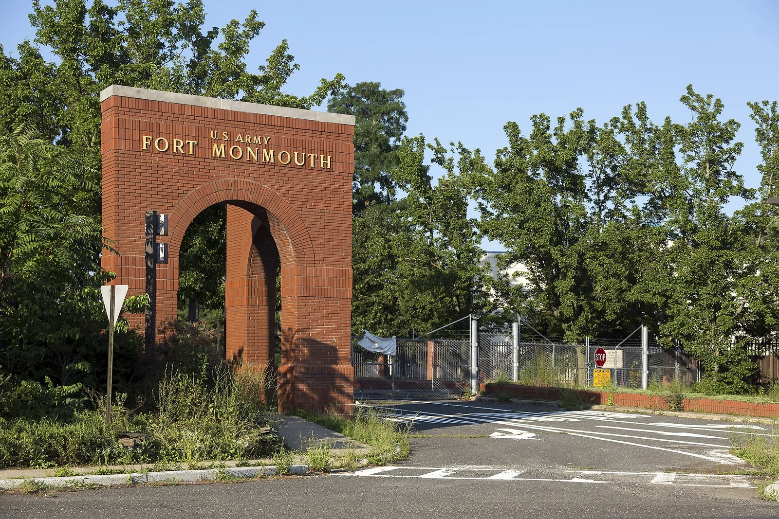 The red brick arch reading U.S. Army Fort Monmouth at the former main gate, with trees behind