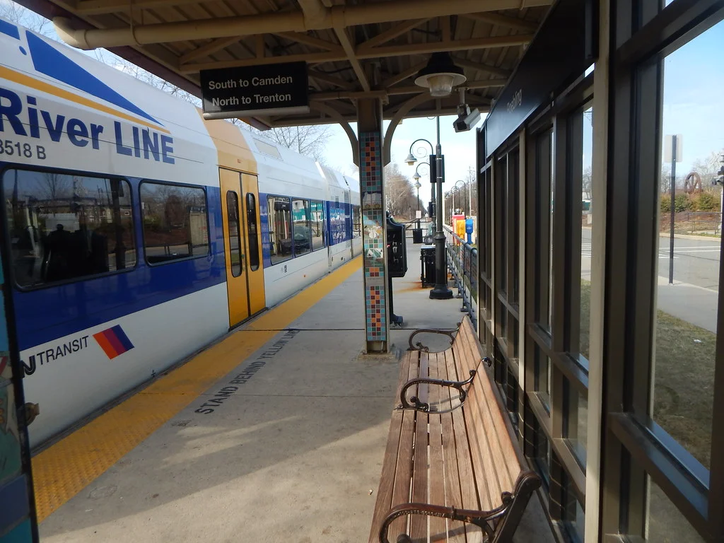 An NJ TRANSIT River Line light rail train stopped at the covered platform of Roebling station