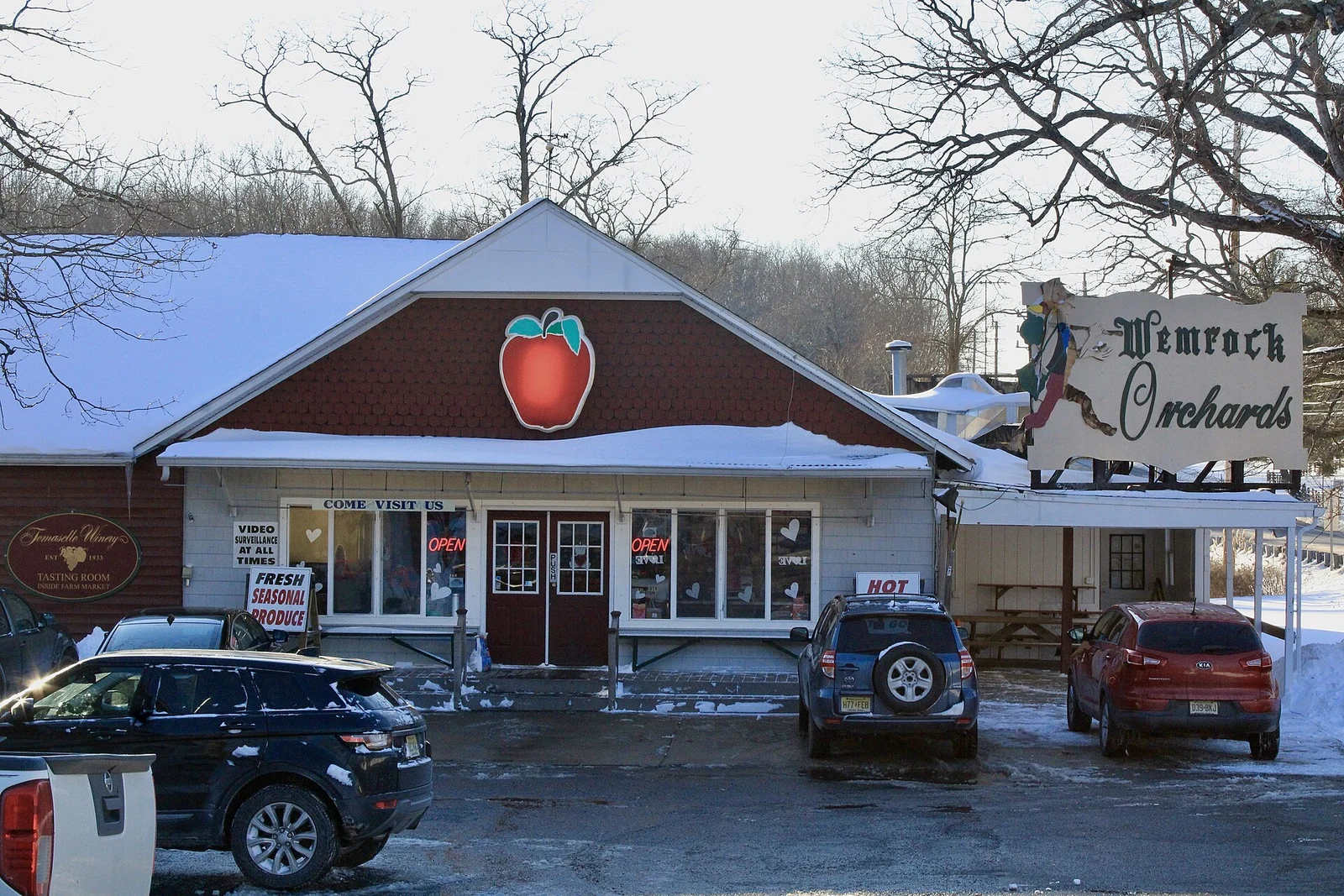 The red-roofed Wemrock Orchards farm market with a big apple sign over the door and a dusting of snow