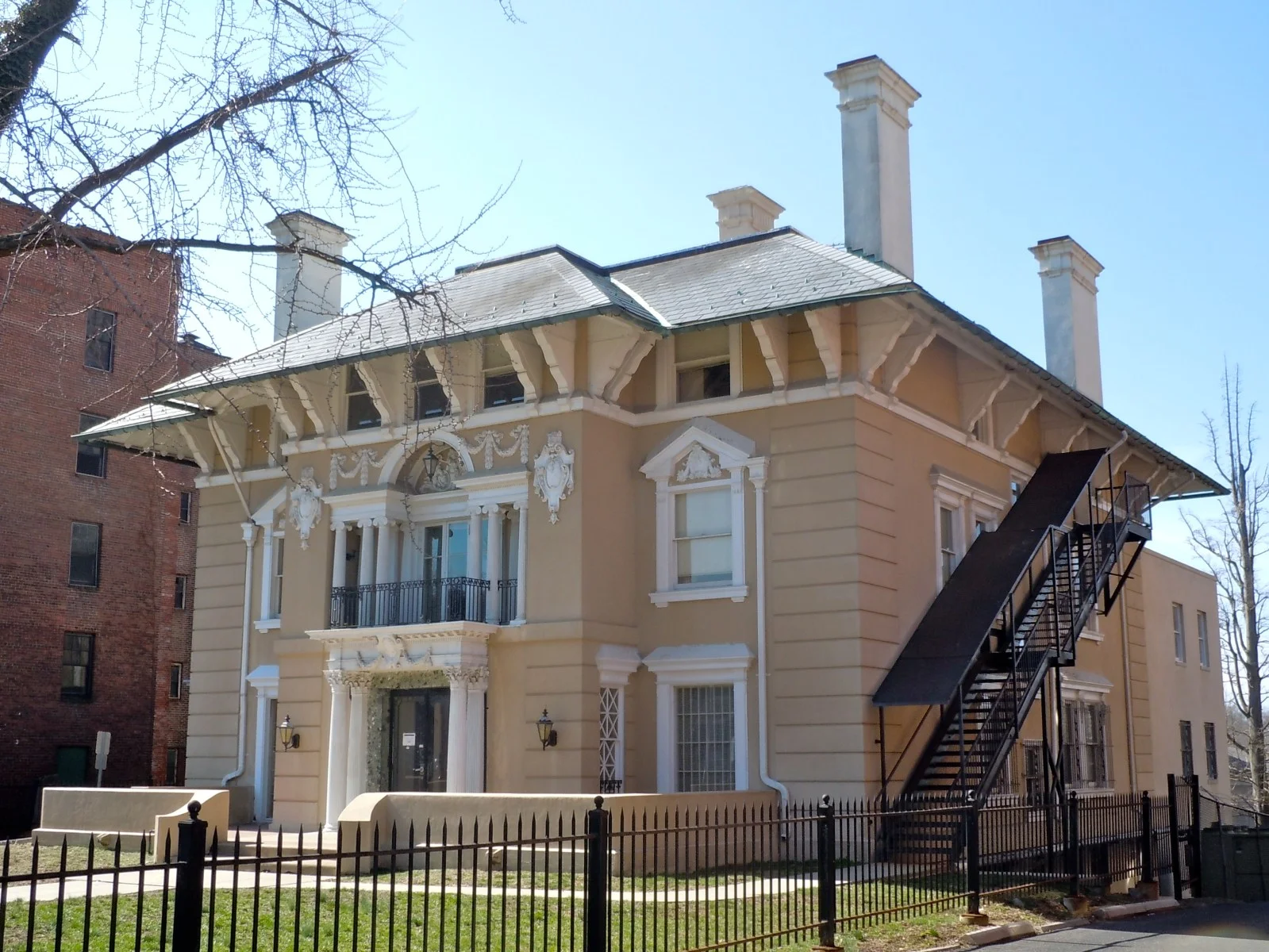 The Queen Anne-style Kuser Farm Mansion with its wraparound porch and gables behind a green lawn