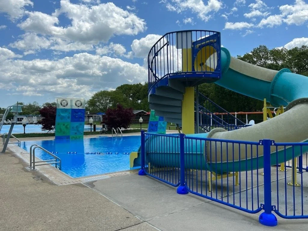 A spiral water slide and climbing wall beside the dive tank at the Hazlet Swim & Tennis Club