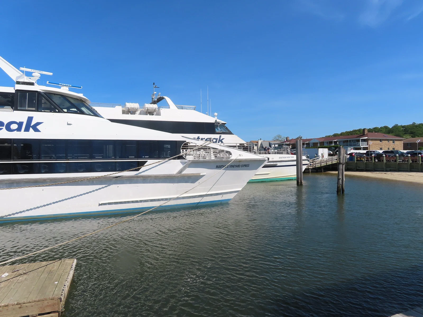 Two white Seastreak high-speed ferries docked at the Highlands terminal on a sunny day