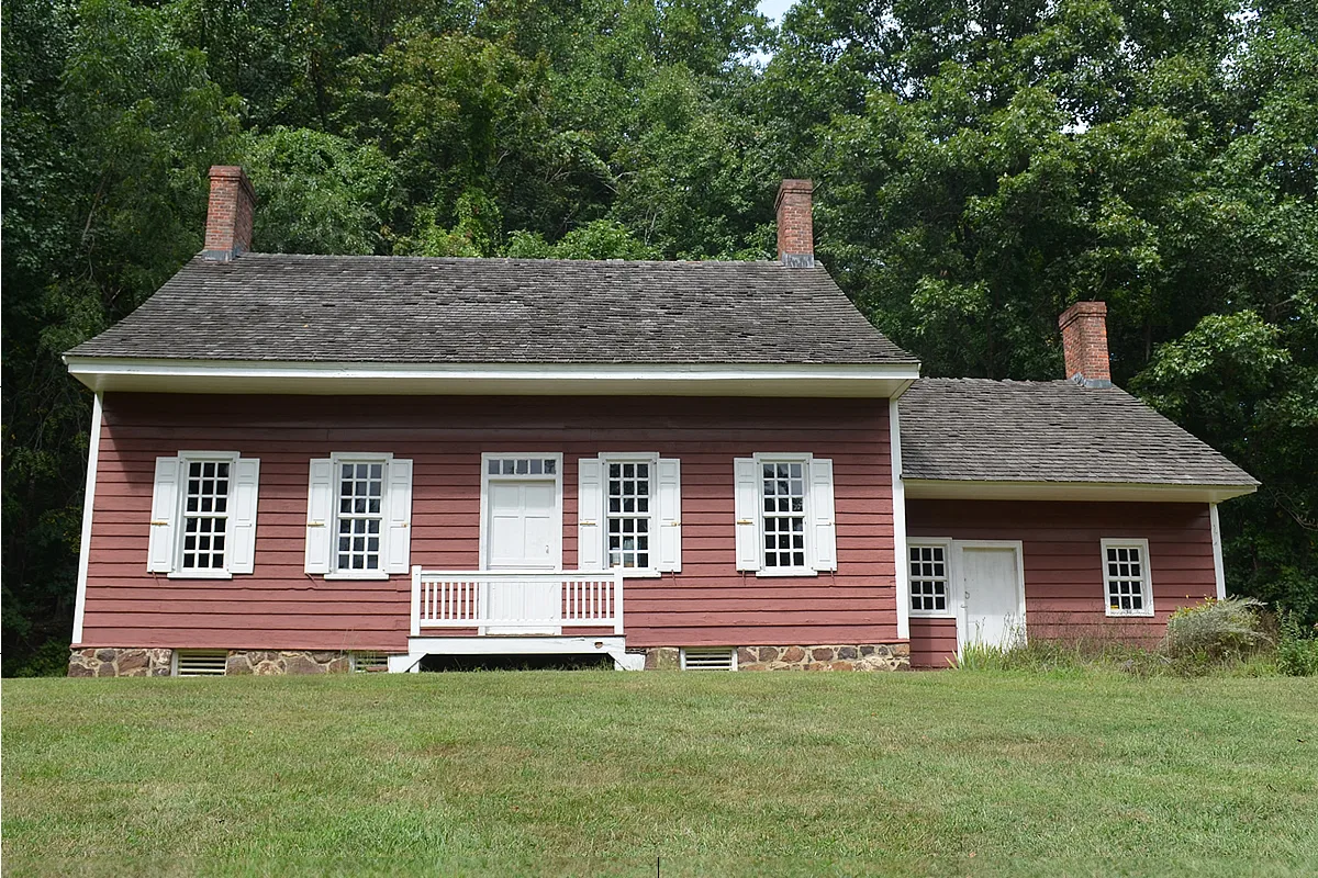 The red Holmes-Hendrickson House, an 18th-century Dutch-style farmhouse, on a green lawn