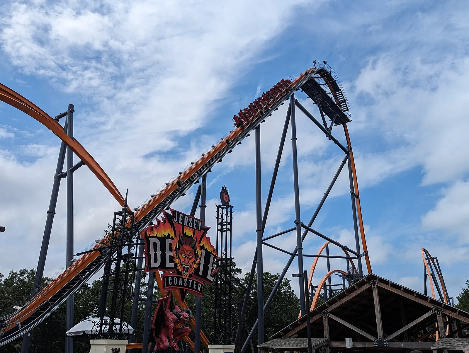 The orange Jersey Devil Coaster track climbing against a blue sky at Six Flags Great Adventure
