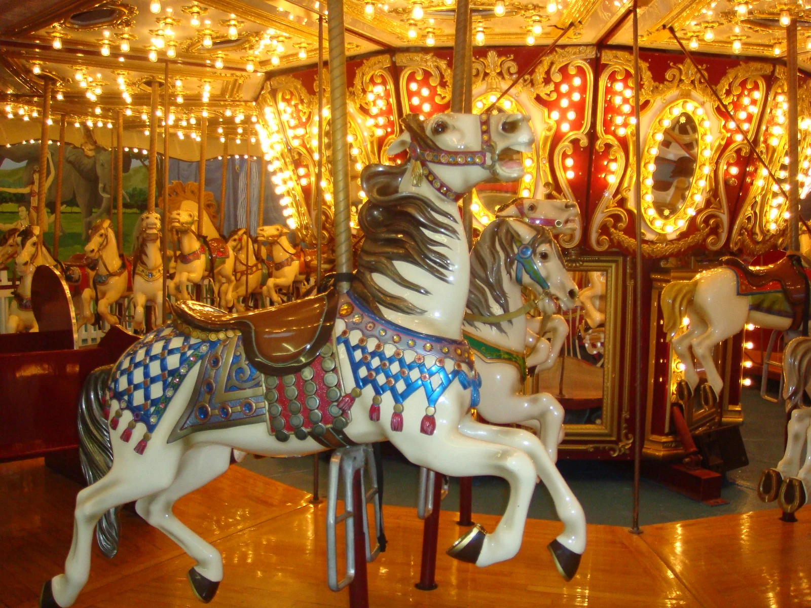 A painted white carousel horse under rows of glowing lights on the carousel at Keansburg Amusement Park