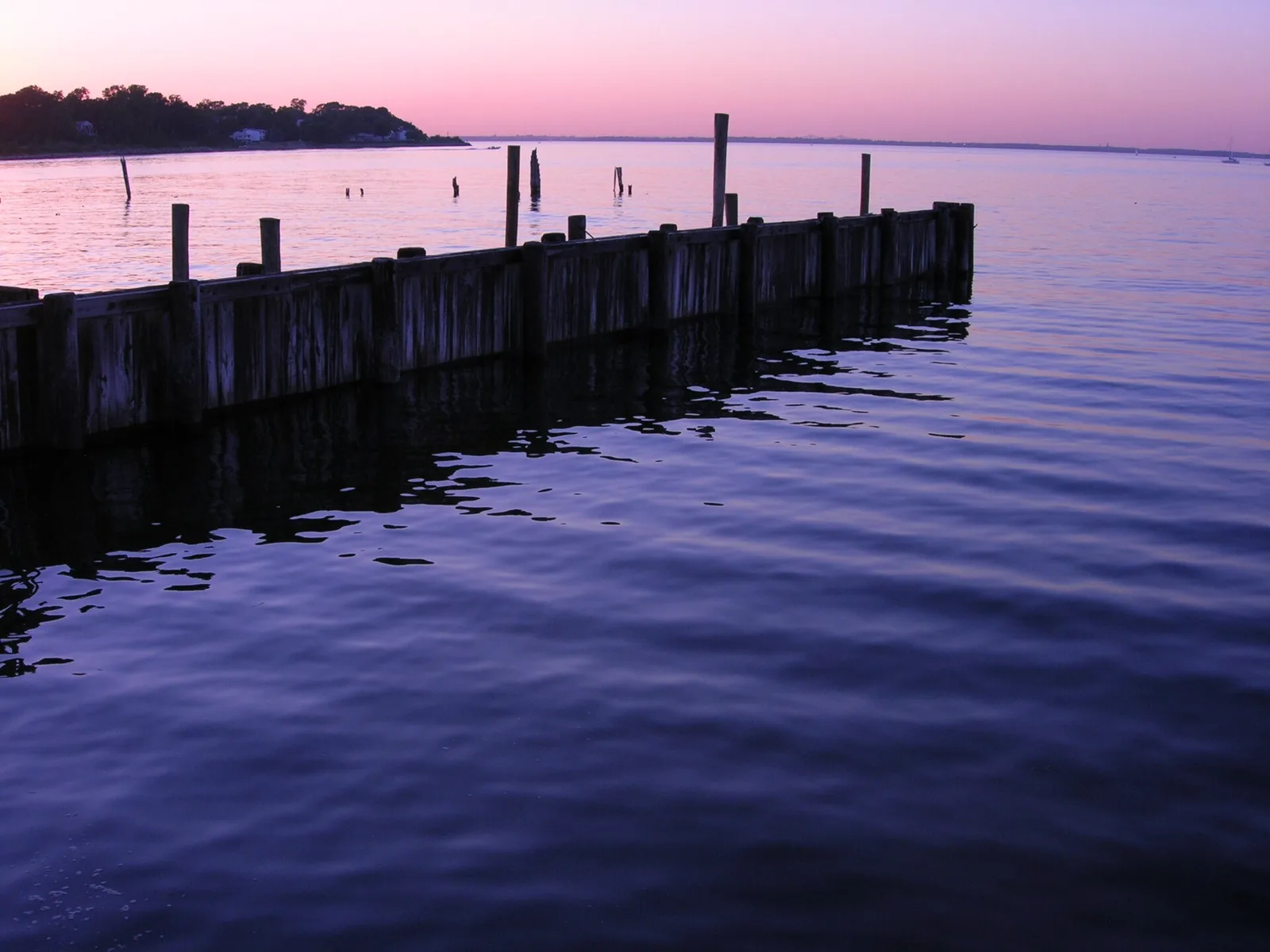 Old wooden pilings and a pier on the Keyport waterfront at dusk, the Raritan Bay glowing pink and purple