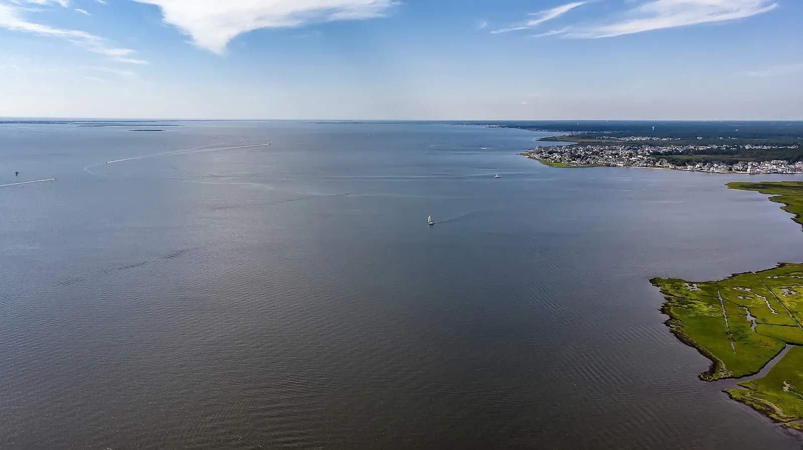 Aerial view over Barnegat Bay with marsh in the foreground and a shoreline in the distance