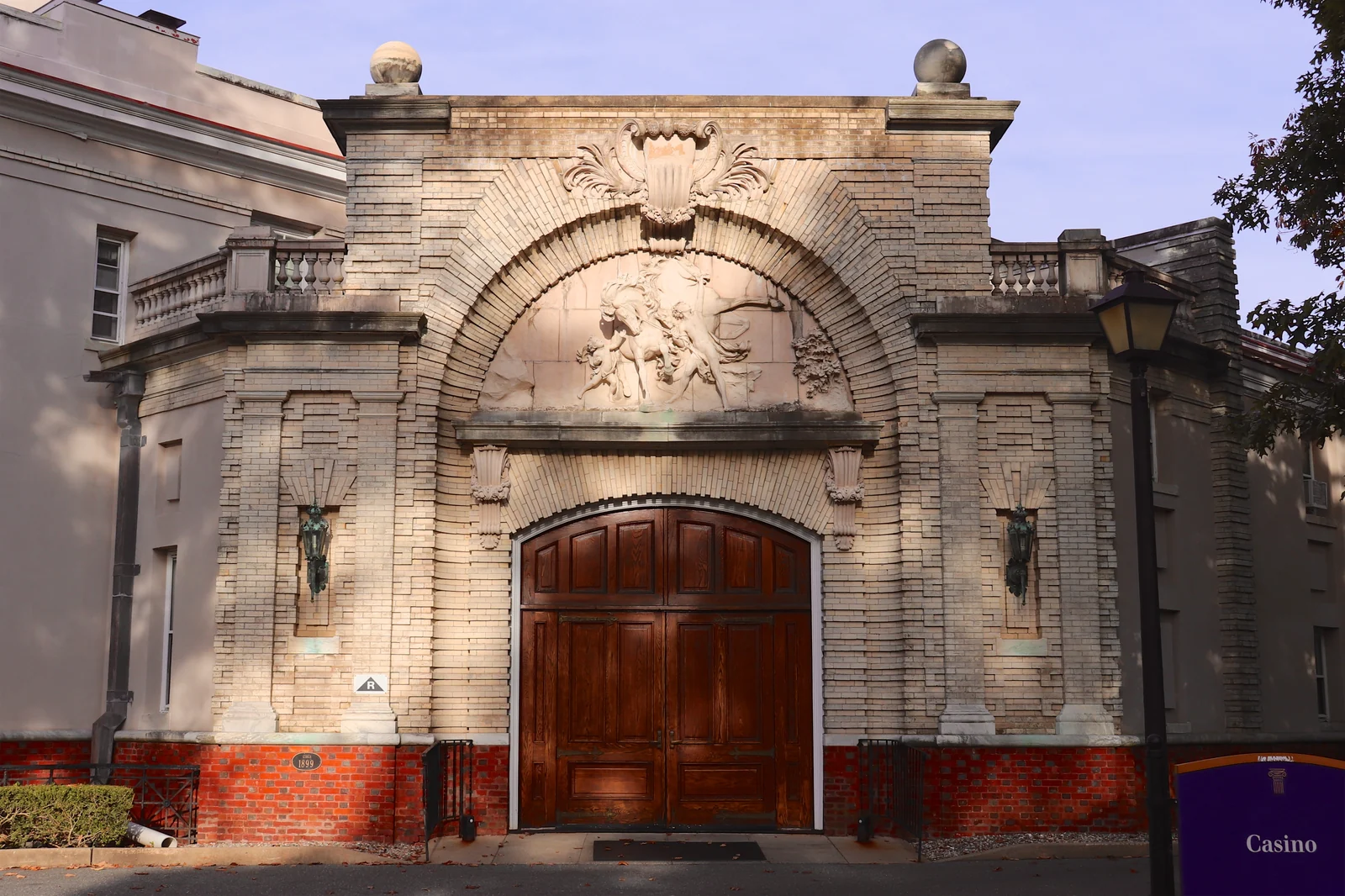 Carved stone archway and tall wooden doors at the eastern entrance of the Casino building at Georgian Court