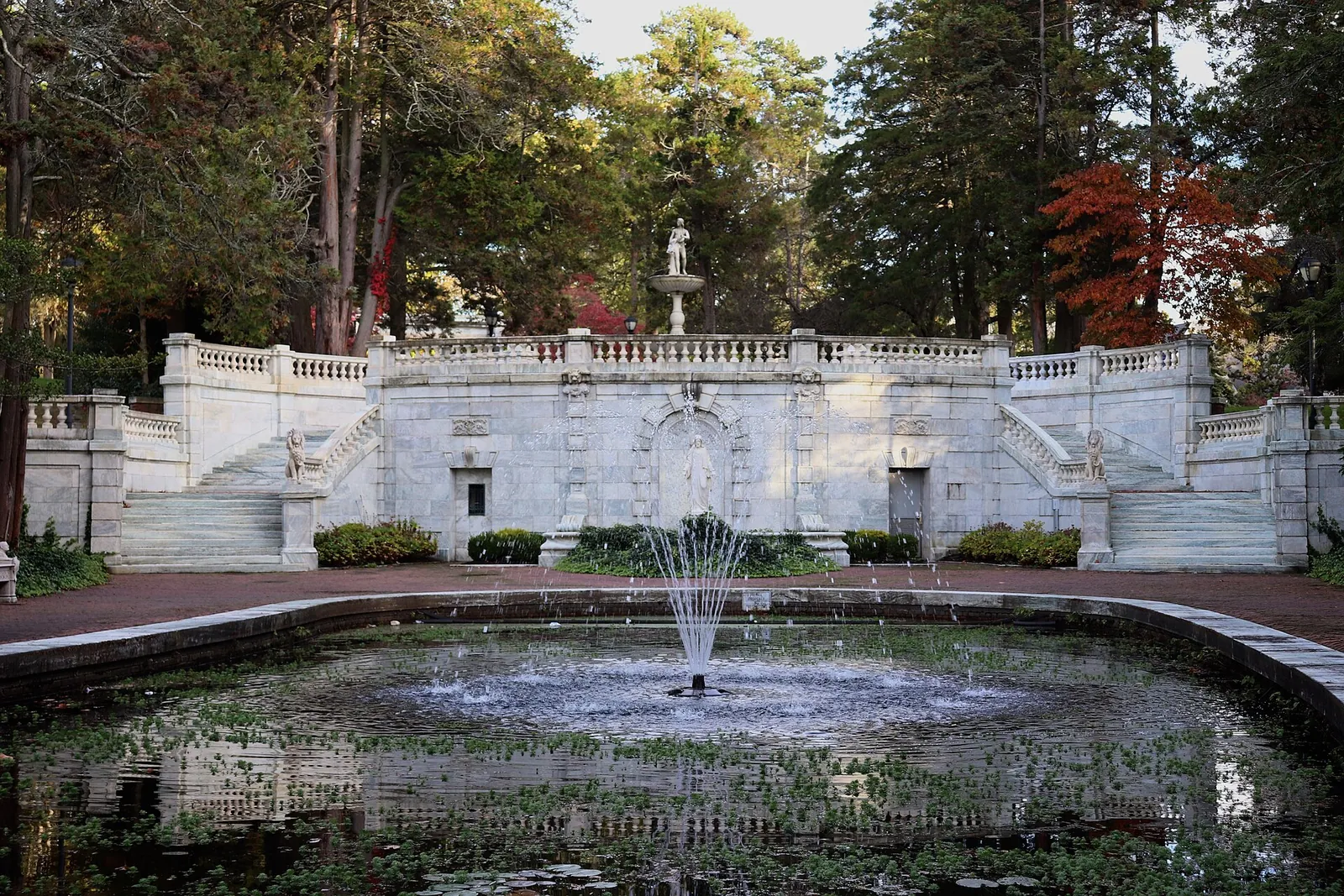 Fountain in the sunken garden pool below a white marble stairway and balustrade at Georgian Court