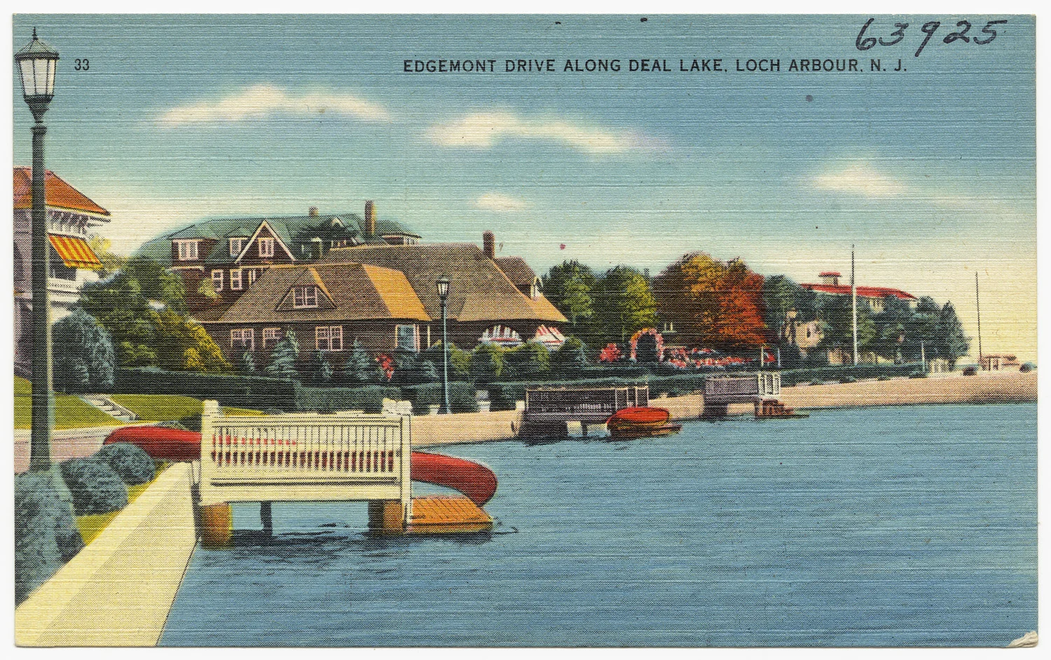Vintage linen postcard of a white lakeside bench and red canoes on Deal Lake, with shingled homes and fall trees along Edgemont Drive
