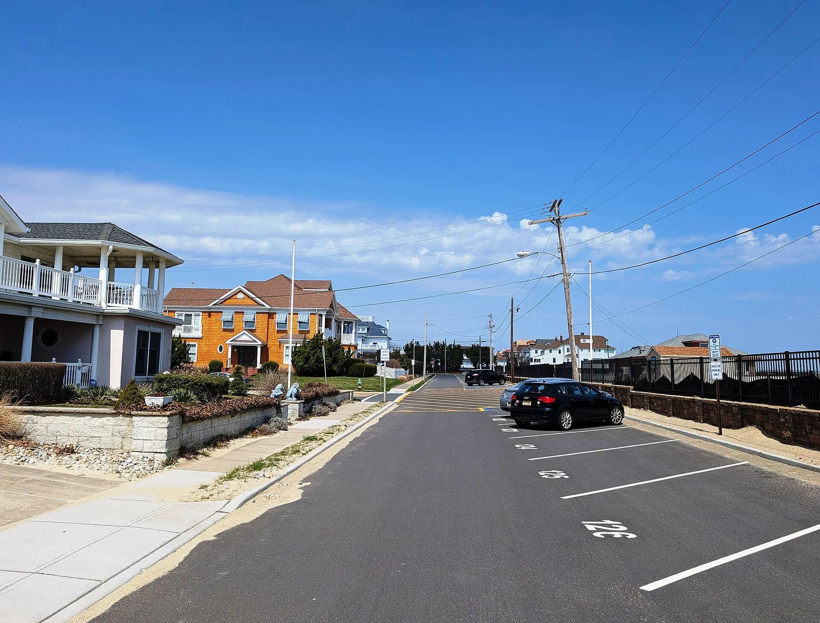 Large homes along Ocean Place in Loch Arbour, with beach parking along the street