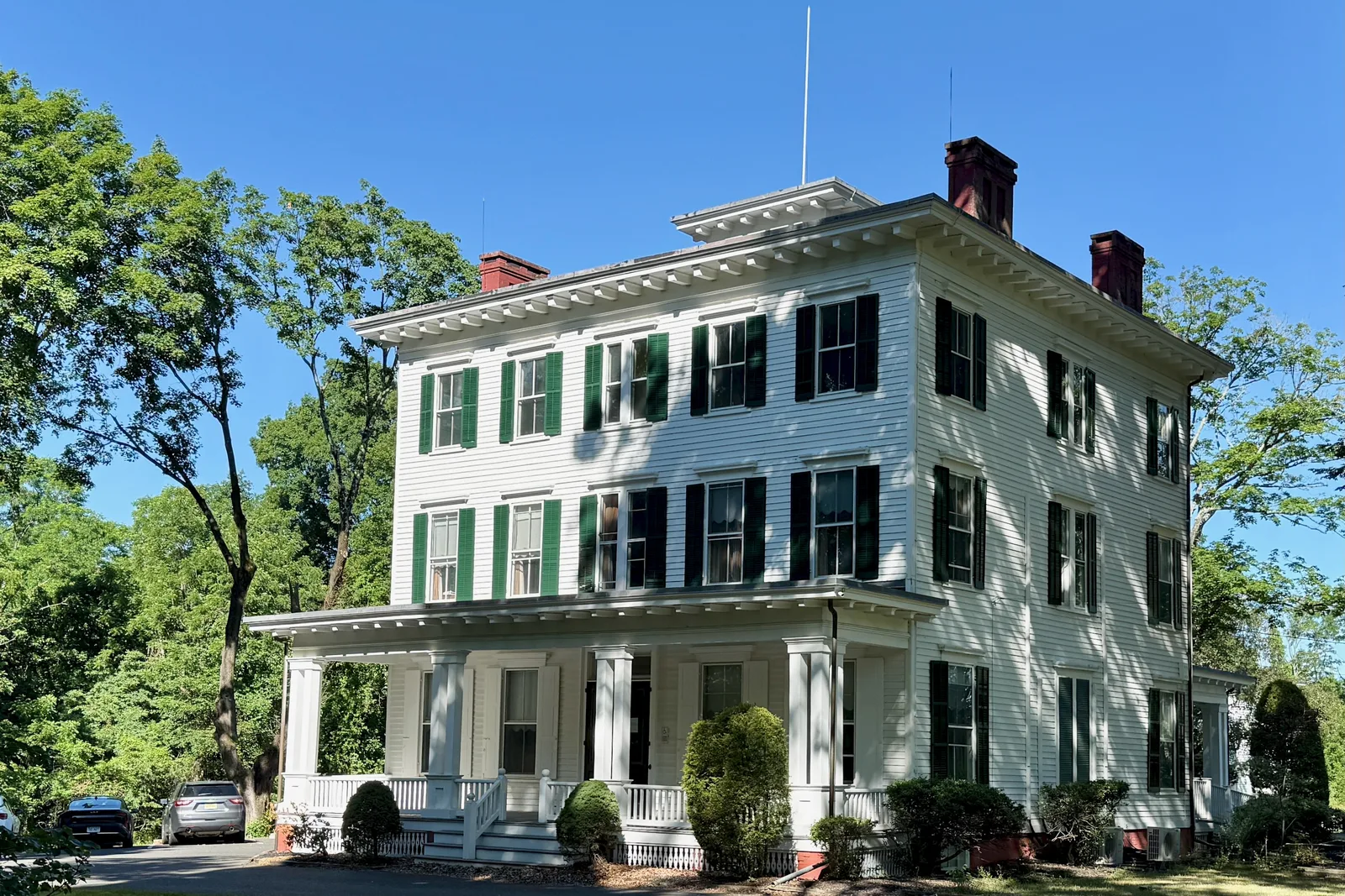 The white Italianate Cobb House, headquarters of Monmouth Battlefield State Park, with a wide front porch
