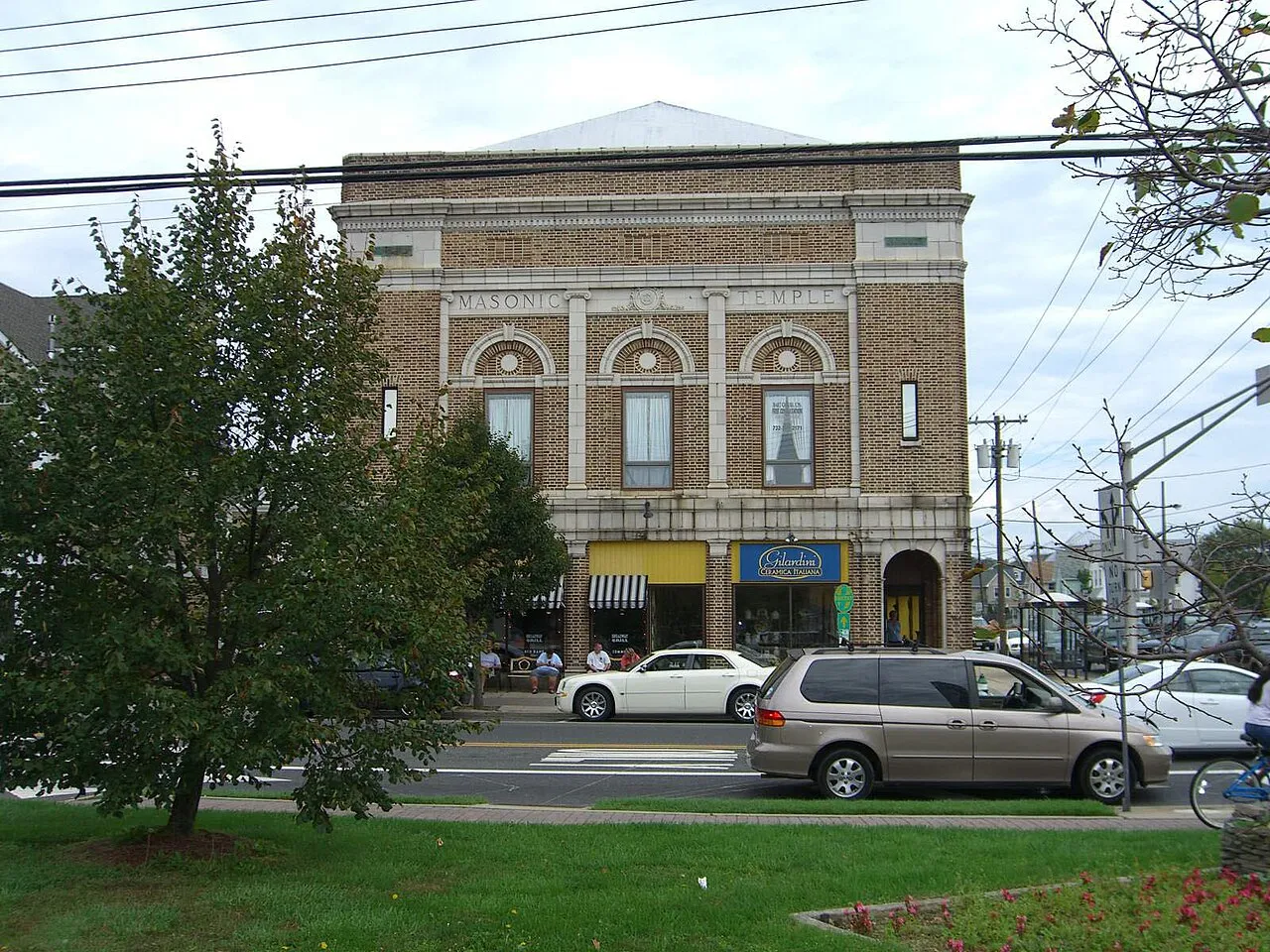 Ornate tan brick building with arched windows above downtown shops