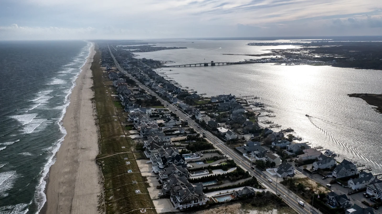 Aerial view south over Mantoloking showing the ocean beach, a row of homes along Route 35, Barnegat Bay and the Mantoloking Bridge in the distance