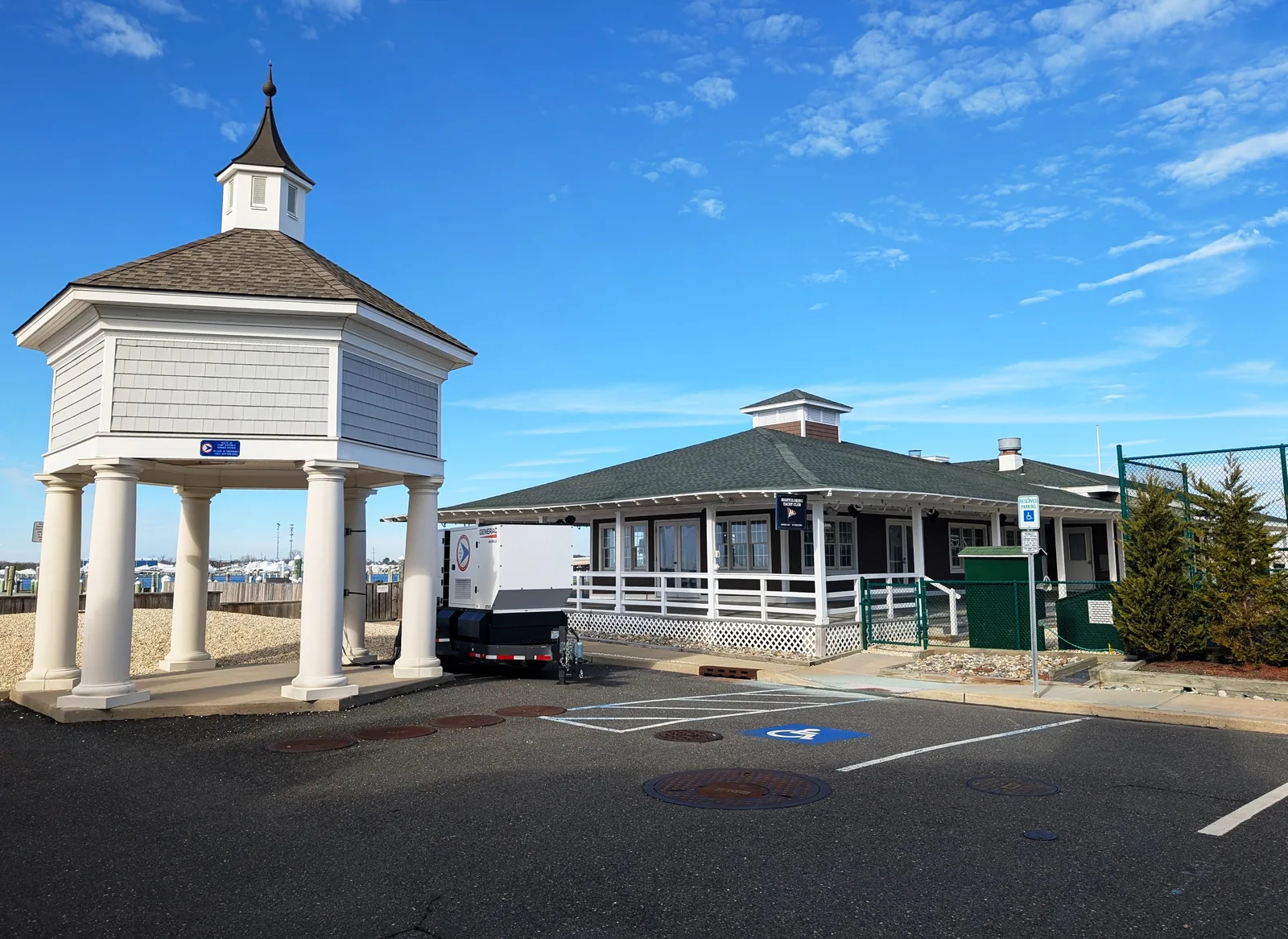 The Mantoloking Yacht Club clubhouse and its white cupola pavilion under a blue sky