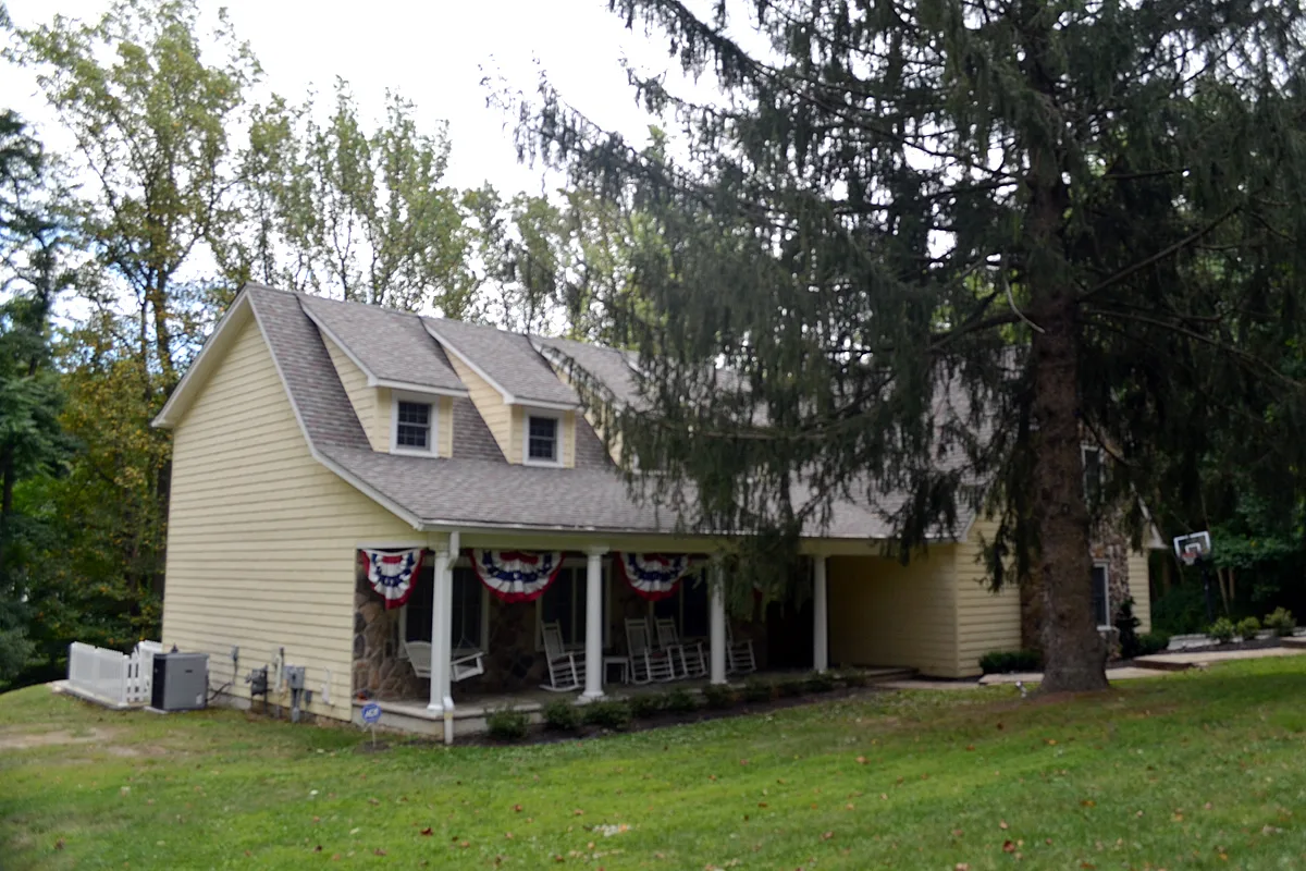 A cream-colored house with a gambrel roof and porch on Pleasant Valley Road in Marlboro