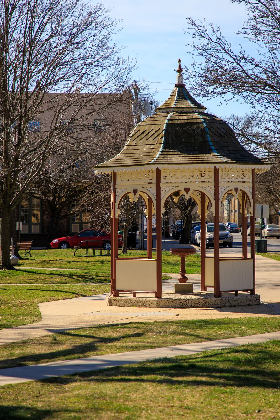 The ornate Victorian gazebo over Beersheba Well, with carved trim and a pedestal fountain inside, on a spring day