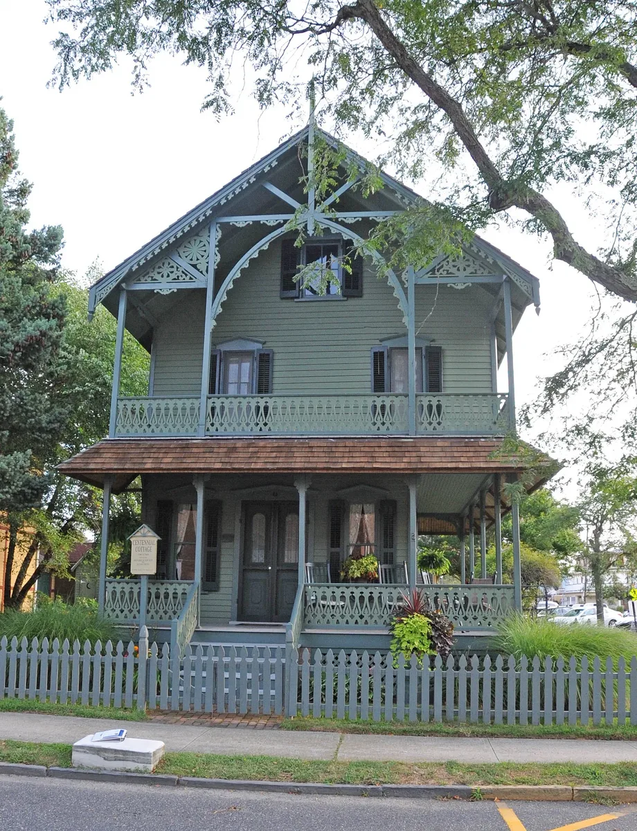 Centennial Cottage in Ocean Grove, a Swiss chalet style house built in 1884 with carved trim and a picket fence