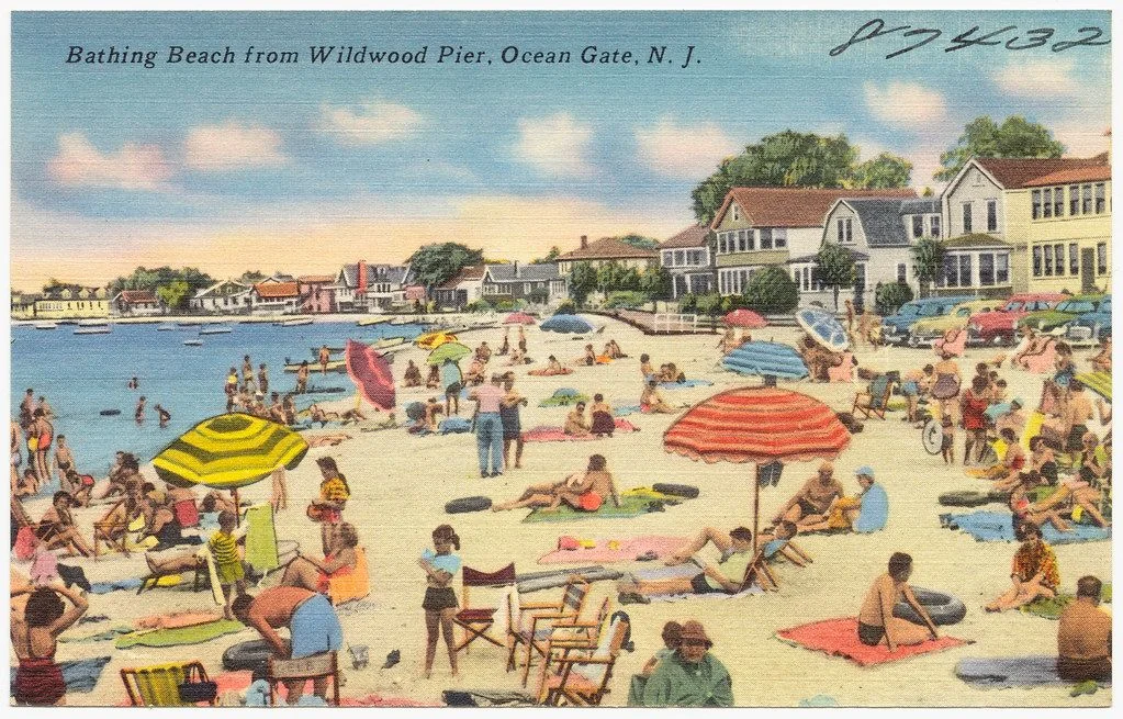 Vintage postcard of a crowded bathing beach on the Toms River with striped umbrellas, beach chairs and houses behind the sand