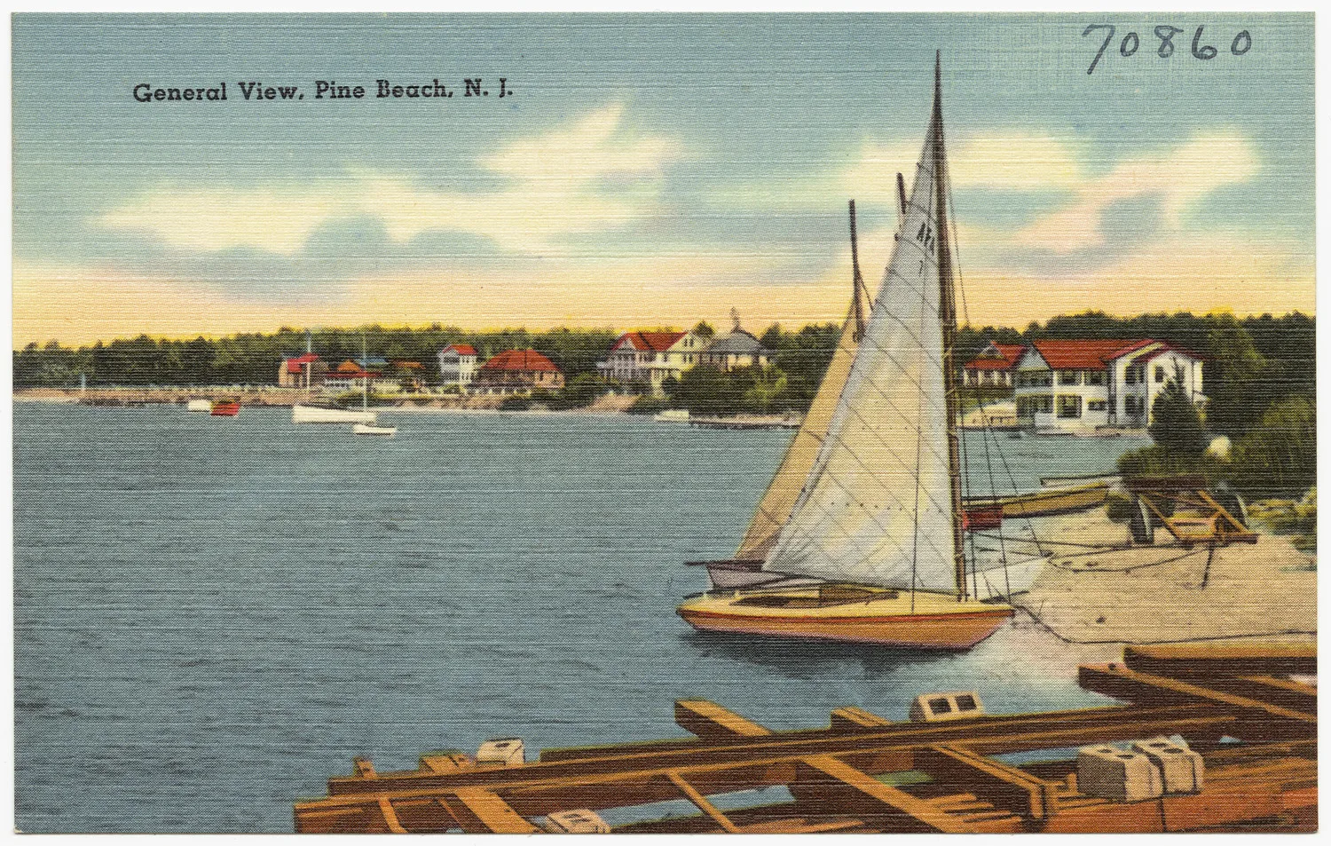 Vintage postcard of a sailboat pulled up on the Pine Beach shore with houses along the river behind it