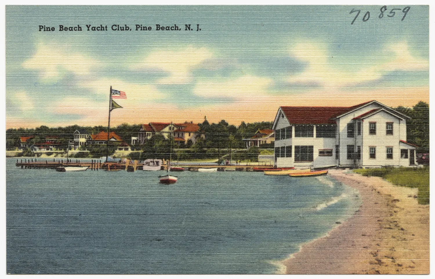 Vintage postcard of a white two-story clubhouse beside a sandy beach and small boats
