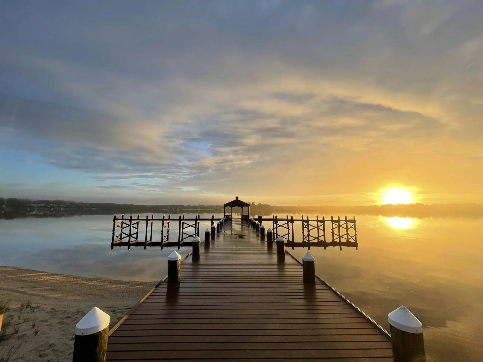 Sunrise over the Toms River seen down a long wooden pier with a gazebo at its end, from the Pine Beach shore